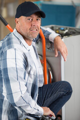 Naklejka na ściany i meble male technician fixing washing machine