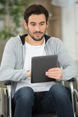wheelchair bound man using digital tablet at home