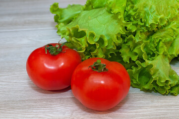 Red tomatoes and lettuce on the table. Vegetarian healthy food