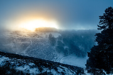 View of foggy morning overlooking welsh landscape during winter season. beautiful morning view of snowy mountains