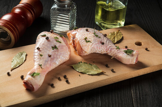 Сhicken legs on a cutting board with spices. The idea of cooking lunch or breakfast in a restaurant
