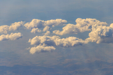 Beautiful white clouds in blue sky. View from airplane