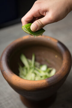 Close-up Of Hand Squeezing Lemon In Bowl
