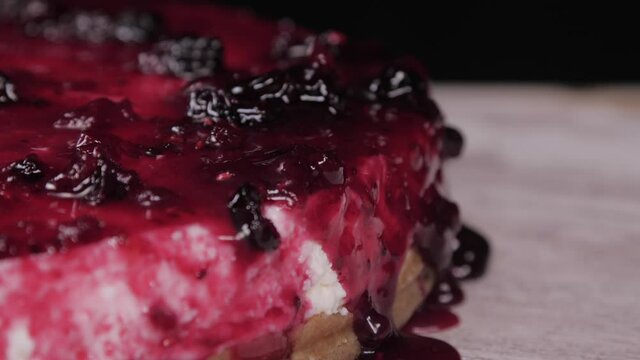 pouring raspberry sauce on top of berry pie 4k