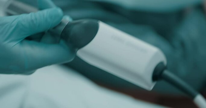 Close-up view of control panel the dental intraoral scaner and dentist right hand in blue latex gloves that take a handscanner.