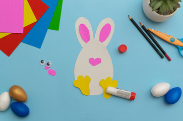 Happy Easter day.Holiday greeting card with your own hands step by step.Leisure for children.A congratulatory gift.Cute white Easter bunnyon a blue background.Instruction. DIY. step 8