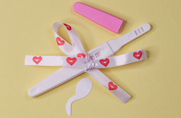 
Pregnancy test with tape.
Pregnancy test with ribbon with hearts and cut out paper sperm on a...