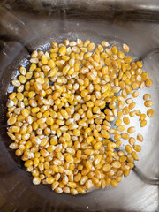 Top view. Raw popcorn corn spread on the bottom of the glass pan.