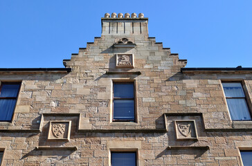 Facade of Stone Tenement Building with Chimneys & Windows seen Against Blue Sky