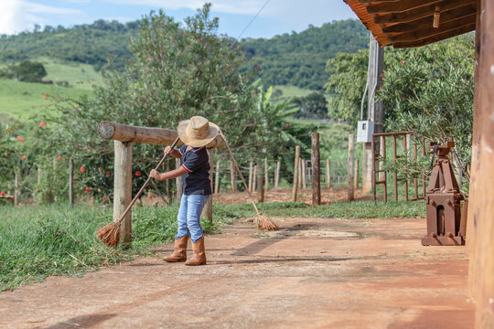 Little farm boy taking care and enjoying the horses. Boy in cowboy outfit taking care of the property and animals.