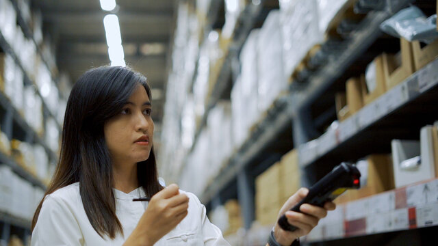 Female Worker Scanning Products With Barcode Scanner In Warehouse.