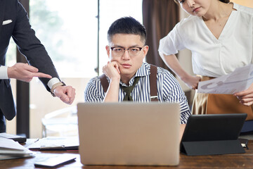 仕事量と締切に追われるアジア人男性ビジネスマン