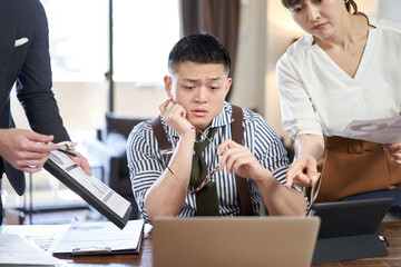 仕事量と締切に追われるアジア人男性ビジネスマン