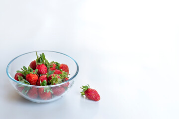 Bowl with strawberries, isolated on white background, landscape format, negative space.