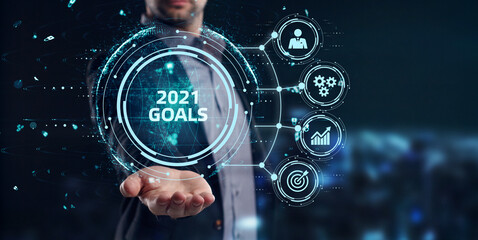 Business, Technology, Internet and network concept. Young businessman working on a virtual screen of the future and sees the inscription: 2021 goals