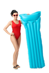 Fototapeta premium Beautiful young woman with inflatable mattress on white background