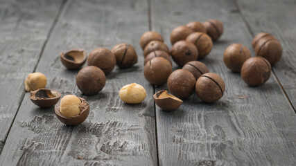 Scattered macadamia nuts on a black wooden table.