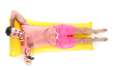 Handsome man lying on inflatable mattress against white background