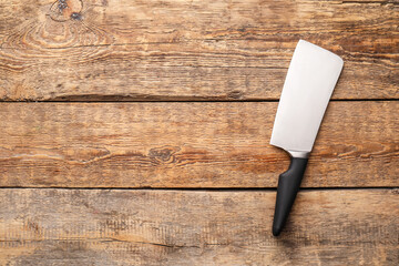 Knife with black handle on wooden background