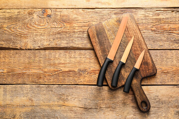 Set of knives on wooden background