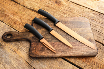 Set of knives on wooden background