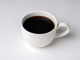 Black coffee in white cup on white background. Studio photography