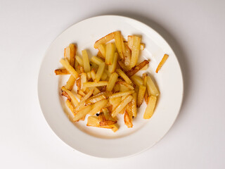 Fried appetizing potatoes on a white plate. Studio photography