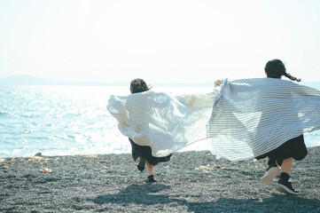 海で布を持って走る姉妹