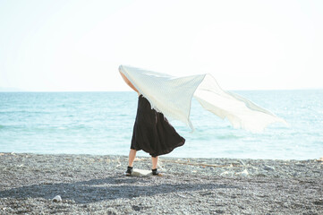 風になびく布と女の子