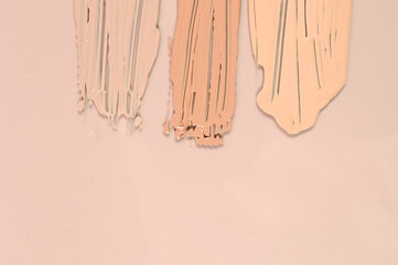  Makeup product smears on pink background. Color set of foundation, top view