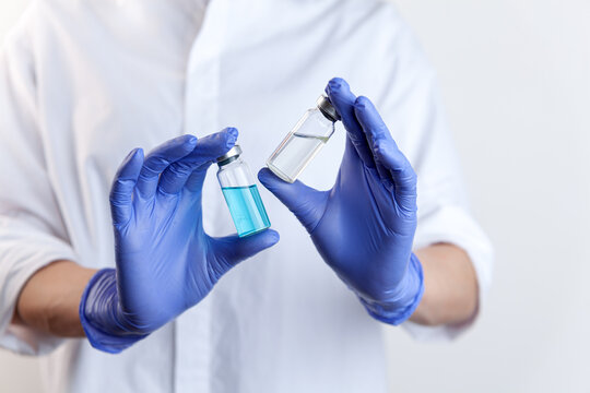 Two Vaccine Bottles In Female Doctor Hands In Protective Gloves