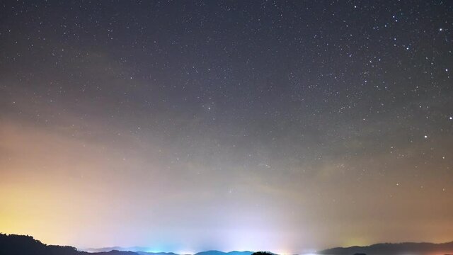 Amazing Starry night in mountains Time lapse.Milky way galaxy stars moving over Mountain countryside with fog flowing on high mountain Night to day Timelapse seen in Phangnga Thailand Beautiful Nature