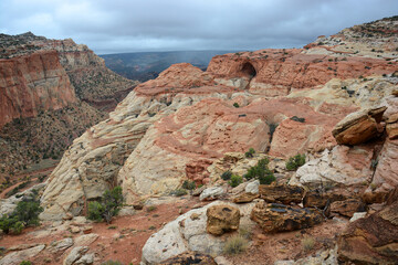 looking up at cassidy's arch and striking eroded rock formations from the cassidy arch trail on a stormy fall day in capitol reef national park, utah