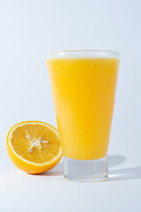 glass of orange juice, with natural orange on white background