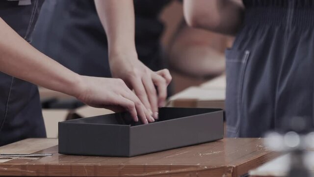 Close up worker hands laminated cardboard box. Modern factory of production cardboard box. Manufacture of cardboard boxes from paper. Enterprise for production package