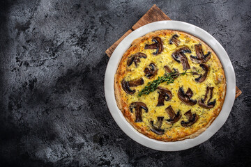 Homemade quiche pie with mushrooms and cheese on dark background, Savory tart pie with mushrooms....