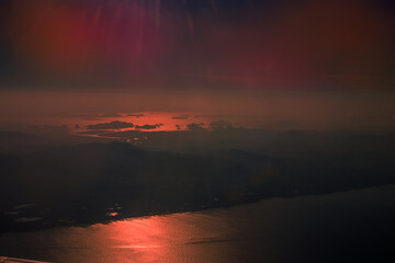 Blurred abstract background from high angle from plane window, overlooking the scenery below (river, mountain, tree).