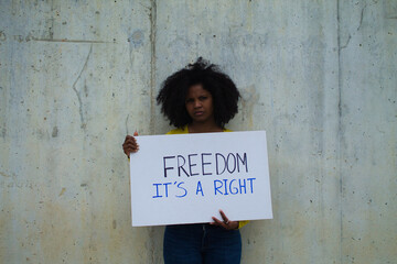 african-american woman with a banner in her hands saying freedom it's a right