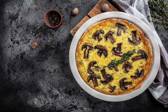 Homemade quiche lorraine with mushrooms, cheese and thyme. Tart with Mushroom pie on dark background. banner, menu recipe place for text, top view