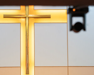Cross at church being filmed by livestream camera which is blurry with a red light in the foreground