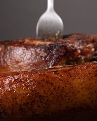 baked piece of pork pierced with a fork close-up