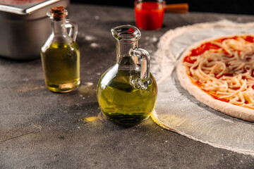 Closeup on jugs of olive oil for making pizza on the grey background