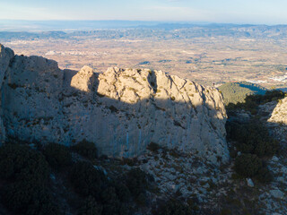 IMAGE OF AN ATHLETE TRAIL RUNNER IN A MOUNTAIN. A PERSON HIKING AT THE TOP OF A MOUNTAIN. RUNNER ON EDGE OF CLIFF. SPORT AND OUTDOOR CONCEPT.