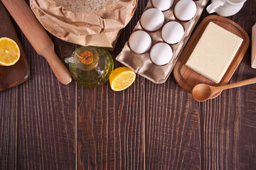 Ingredients for home baking, kitchen utensil on the wooden background. Top view. Copy space.