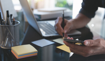 Startup business man planning work project, using mobile phone and laptop computer at office