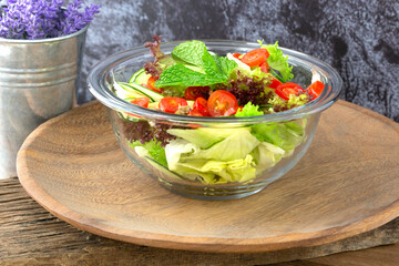 Salad bowl on wooden plate on wood table for healthy meal