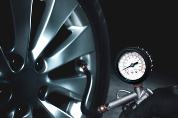Mechanic testing the tire pressure with tire pressure gauge