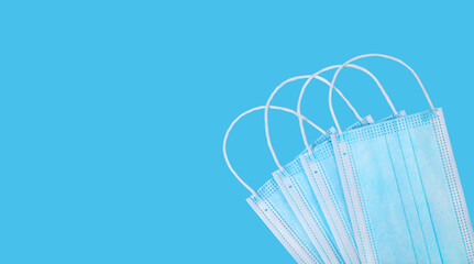 Some medical protective masks on blue background with copy space.