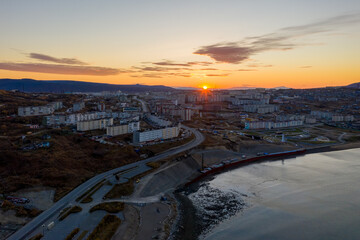 Morning aerial view of the city of Magadan. Top view of the port town. Sunrise over buildings and streets. Autumn city landscape. Magadan, Magadan region, Siberia, Far East of Russia.