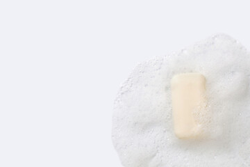 Soap sud and bar of soap on white background. Backdrop with copy space.
